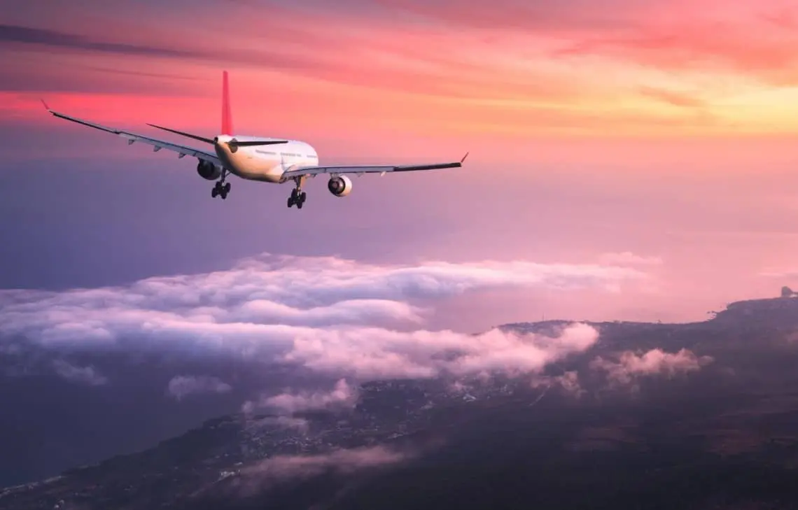 airplane flying at sunset